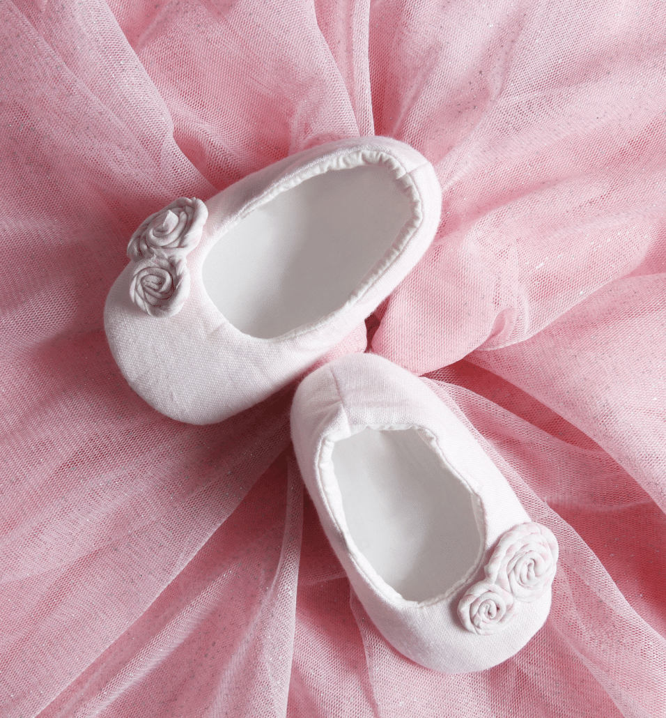 baby girl shoes pink background
